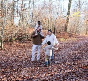 Family walking on a leaf-covered path in autumn